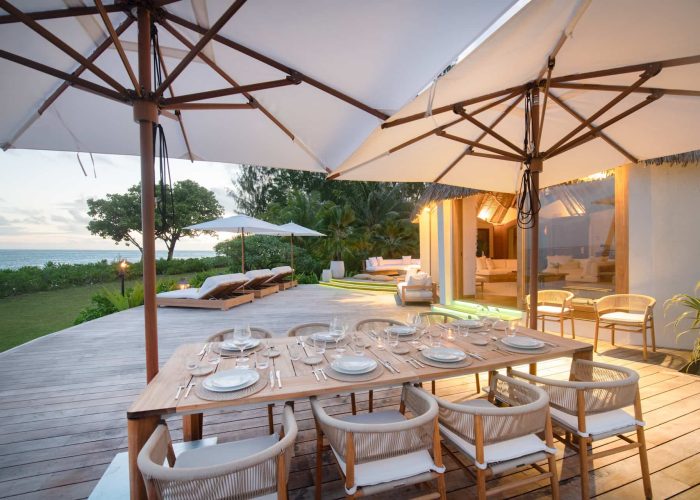 Motu Nao Nao, île privée à Raiatea. Table dressée pour le dîner sur la terrasse de la villa au coucher du soleil.