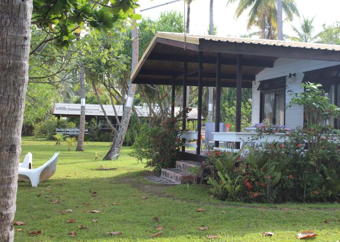 Pension Sunset Beach Motel à Raiatea - extérieur d'un bungalow avec sa terrasse dans le jardin.