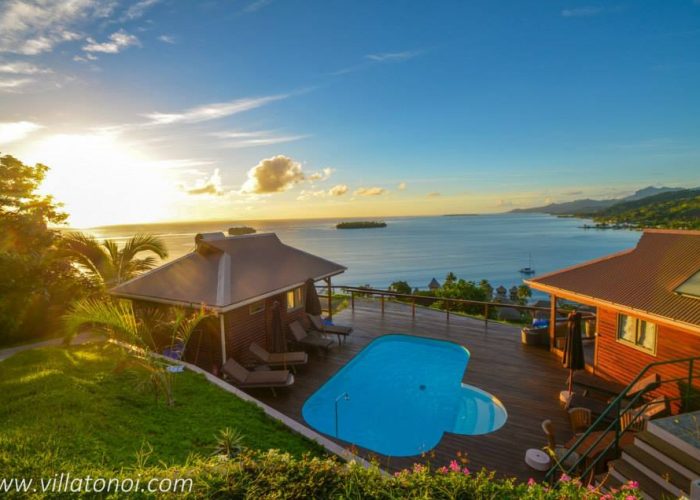 Pension Villa Tonoi à Raiatea. Vue aérienne au coucher du soleil, sur la piscine et deux bungalows. Lagon en arrière plan.