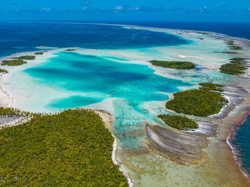 vue aérienne de l'atoll de Rangiroa, au niveau du récif corallien. Vue sur le lagon turquoise et l'océan, ainsi que sur les motus