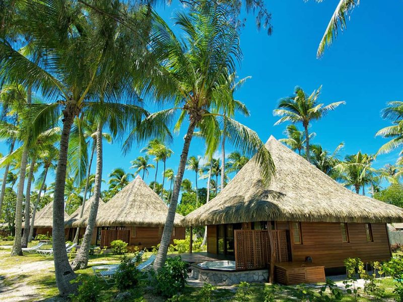 Hôtel Kia Ora 4* à Rangiroa. Vue de l'extérieur d'un bungalow place avec son jacuzzi privée sur la terrasse. Cocoteraie tout autour.