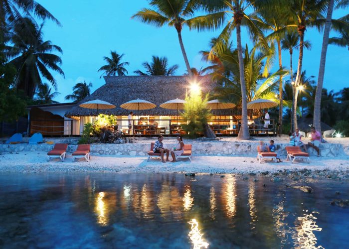 Pension Raira Lagon à Rangiroa. Vue depuis le lagon sur le restaurant à la tombée de la nuit.