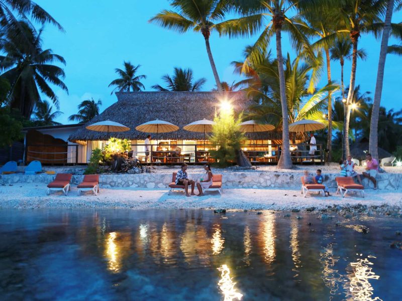 Pension Raira Lagon à Rangiroa. Vue depuis le lagon sur le restaurant à la tombée de la nuit.