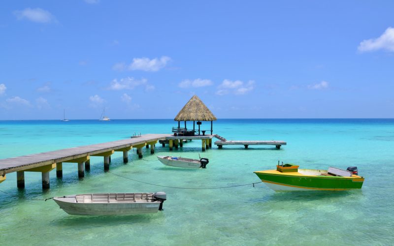 vue sur le lagon de Rangiroa avec un ponton où 3 bateaux sont amarrés. Hôtel Kia Ora à Rangiroa 4****