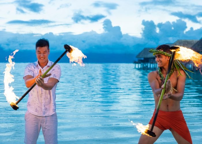 homme polynésien apprenant la danse du feu à un touriste - slow travel