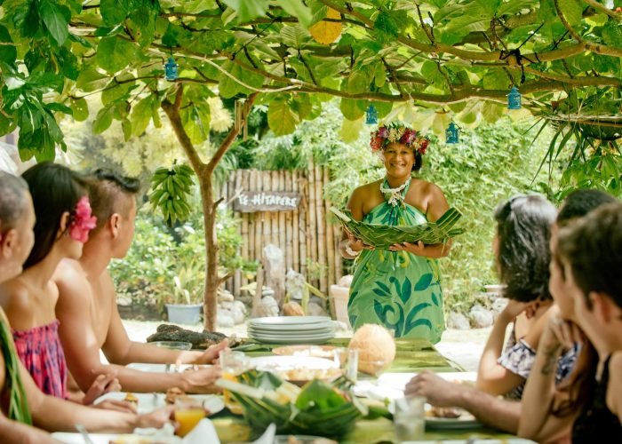 femme polynésienne apportant une spécialité locale à des touristes - slow travel