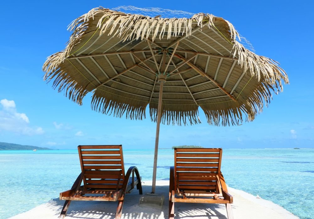 Hôtel Eden Private Island 2* à Taha'a - parasol et transats face au lagon.