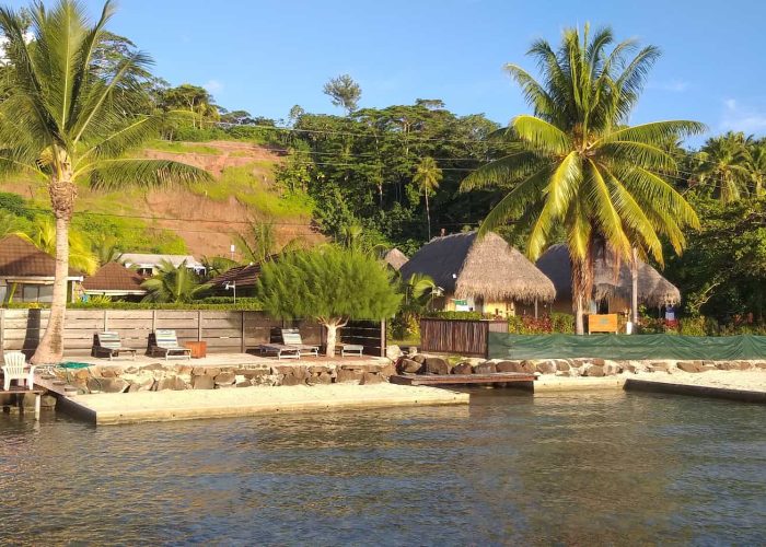 Pension La Perle de Taha'a. Vue depuis le ponton sur la petite plage et les transats de la pension.