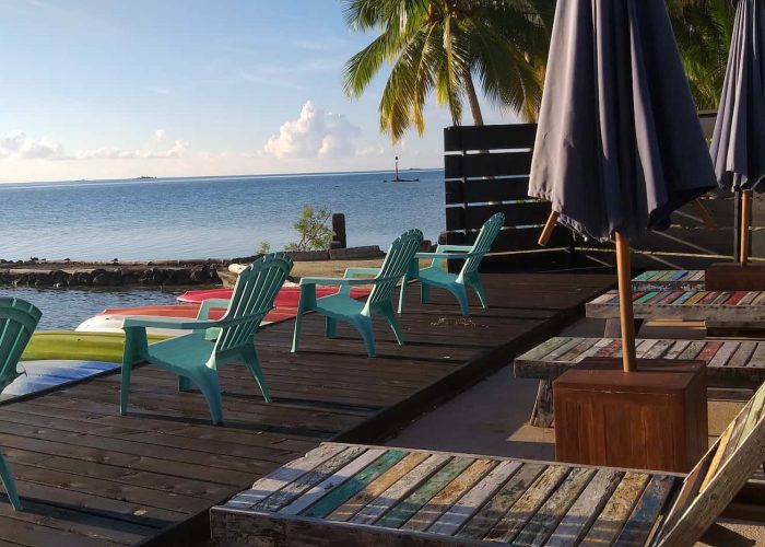 Pension La Perle de Taha'a. Transats et chaises sur le deck de la pension, avec vue sur le lagon.