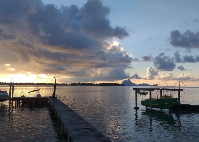 Pension La Perle de Taha'a - vue au coucher du soleil sur le ponton donnant sur le lagon de l'ile de Taha'a. Bora Bora en arrière plan