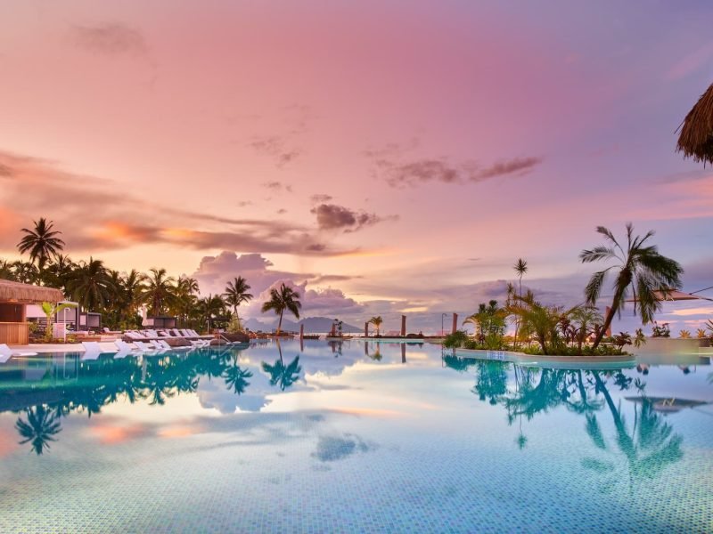 Hôtel Hilton 4* à Tahiti. Vue panoramique piscine au coucher du soleil.