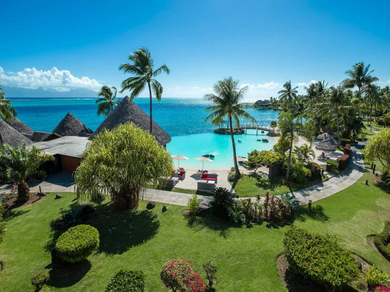 Hôtel Intercontinental Tahiti Resort 4*. Vue depuis une chambre premium, sur la piscine à débordement sur le lagon turquoise. Cocotiers et jardin luxuriant.