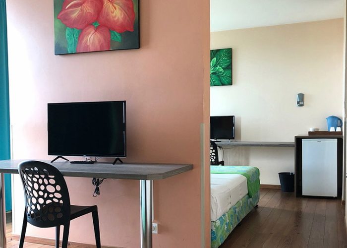 Hôtel Tahiti Airport Motel 2*. Intérieur d'une chambre famille et de ses deus espaces couchages et bureau en enfilade.