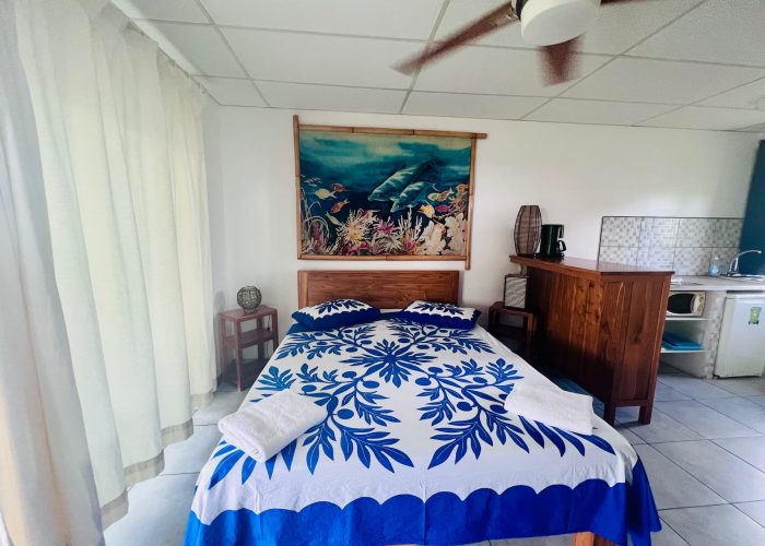 Pension de la Plage à Tahiti - lit double dans un studio avec kitchenette.