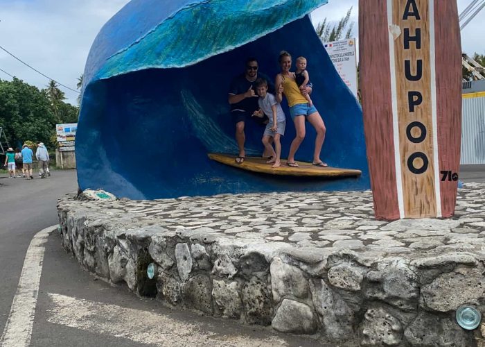 Activité en famille à Tahiti - Couple avec un enfant et un bébé au PK 0 à Teahupoo à Tahiti, sur le planche de surf, en dessous d'une vague artificielle.