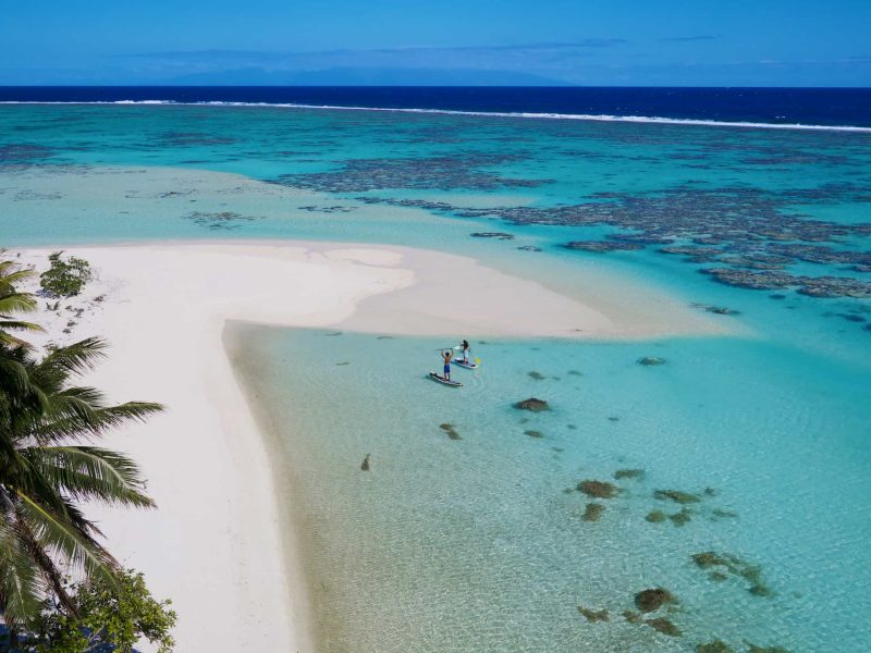 Hôtel The Brando 5* à Tetiaroa - vue aérienne de la plage et du lagon, avec une homme et une femme faisant du paddle