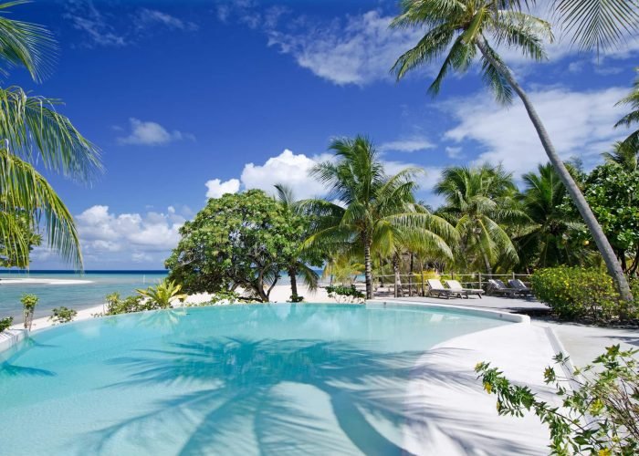 subtiles-tahiti-tikehau-hôtel-le-tikehau-by-pearl-resorts-4©le-tikehau-by-pearl-resorts Hôtel Le Tikehau by Pearl Resorts 4*- piscine à débordement sur le lagon, entourée de palmiers.