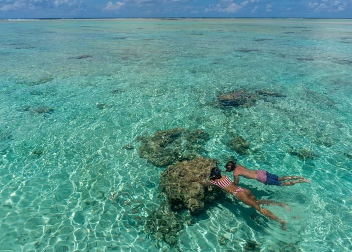 Pension Ninamu Resort à Tikehau - couple faisant du snorkelling dans le lagon turquoise.