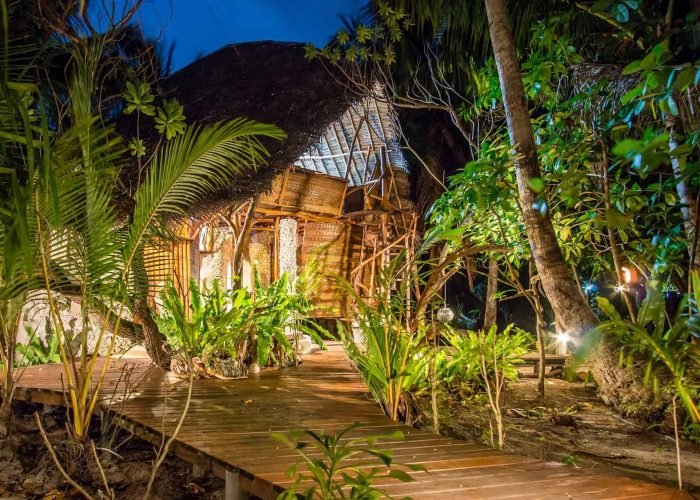 Pension Ninamu Resort à Tikehau - Extérieur d'un Bungalow Supérieur Jardin Tamanu à la tombée de la nuit.