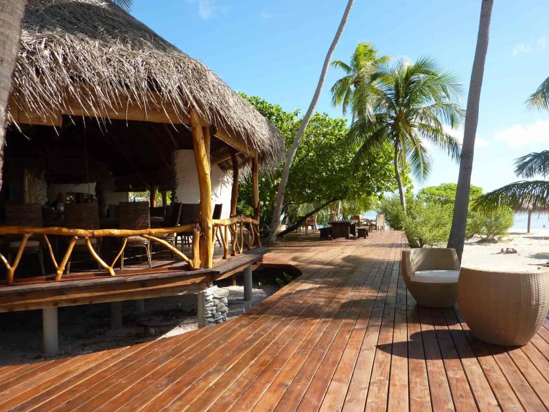 Pension Ninamu Resort à Tikehau. Vue sur le deck du bar, plage et cocotiers.