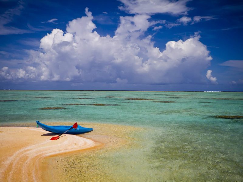 Pension Ninamu Resort à Tikehau. Vue sur un banc de sable avec un kayak, et lagon turquoise.