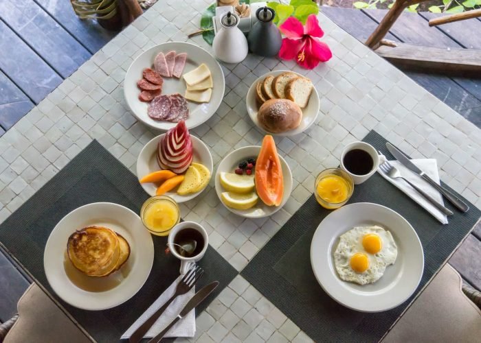 Pension Ninamu Resort à Tikehau - Vue en hauteur d'un petit-déjeuner servi à une table.