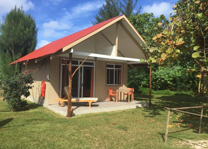 Pension Wipa Lodge à Tubuai, archipel des Australes - Extérieur d'un bungalow avec sa terrasse meublée dans le jardin de la propriété.