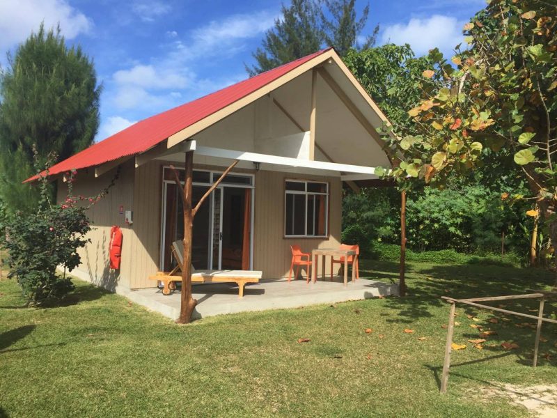 Pension Wipa Lodge à Tubuai, archipel des Australes - Extérieur d'un bungalow avec sa terrasse meublée dans le jardin de la propriété.