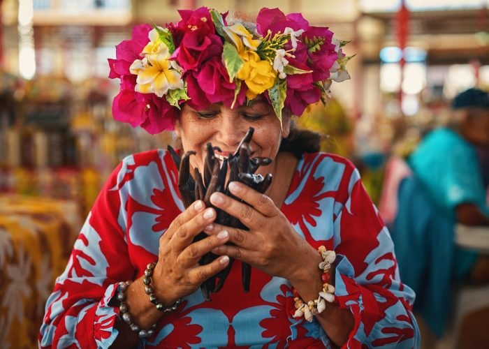 femme polynésienne humant des gousses de vanille de tahiti